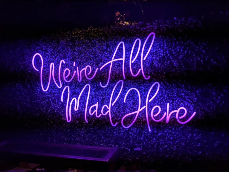 neon sign above bench on purple glowing background