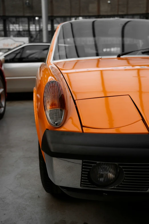 a close up of the front end of an orange car