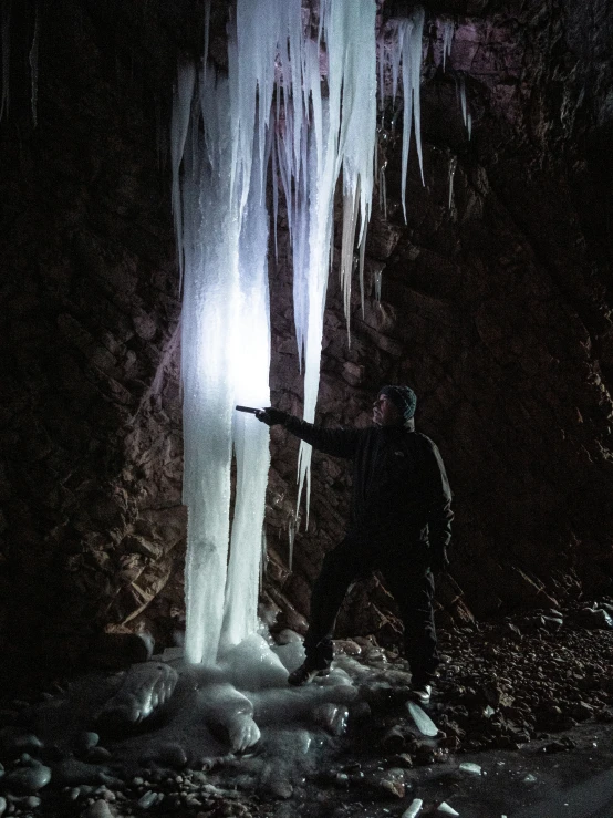 a person standing near the water holding a rifle in his hand