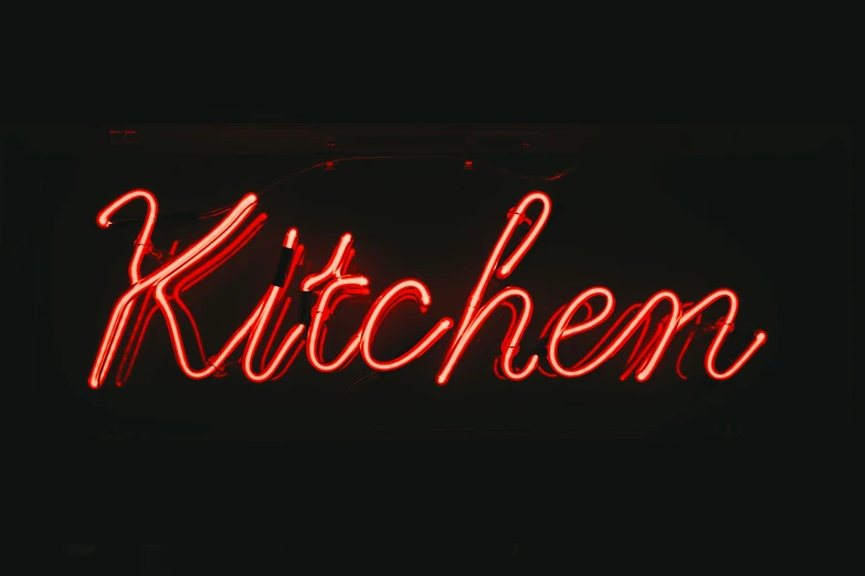 a kitchen neon sign lit up in the dark