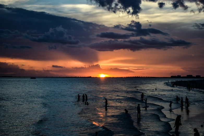 the sun is setting at the beach during the day