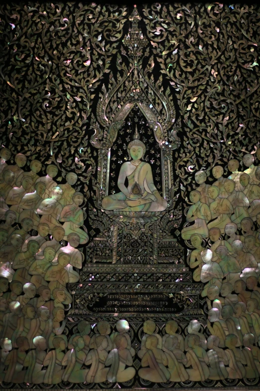 a buddha statue surrounded by silver rocks and a black background