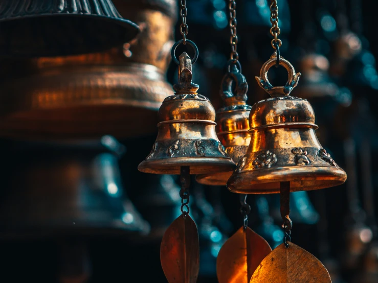 two bells hanging from a row with a bell on a chain