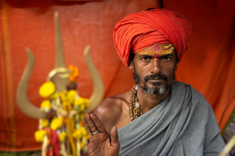 a man dressed as an indian god standing in front of a red background