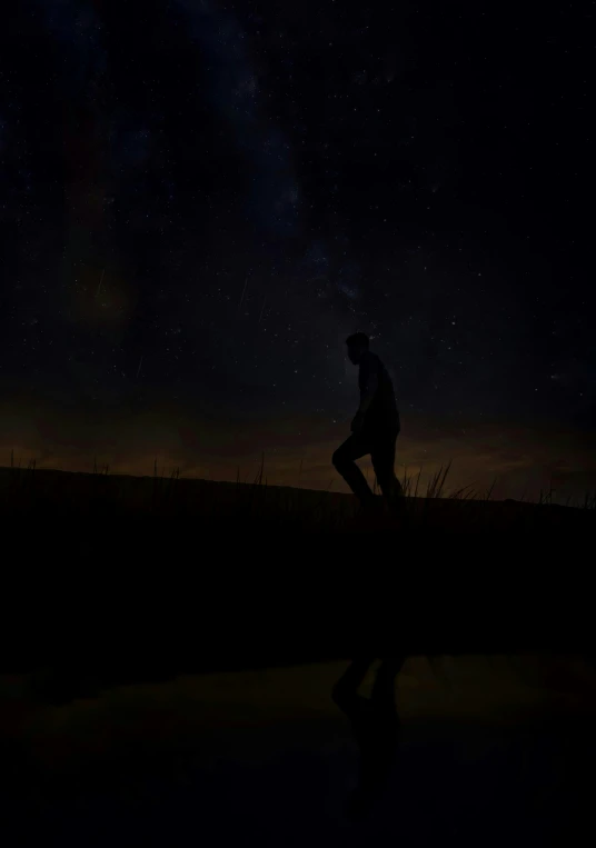 a man is standing in the field by a dle at night