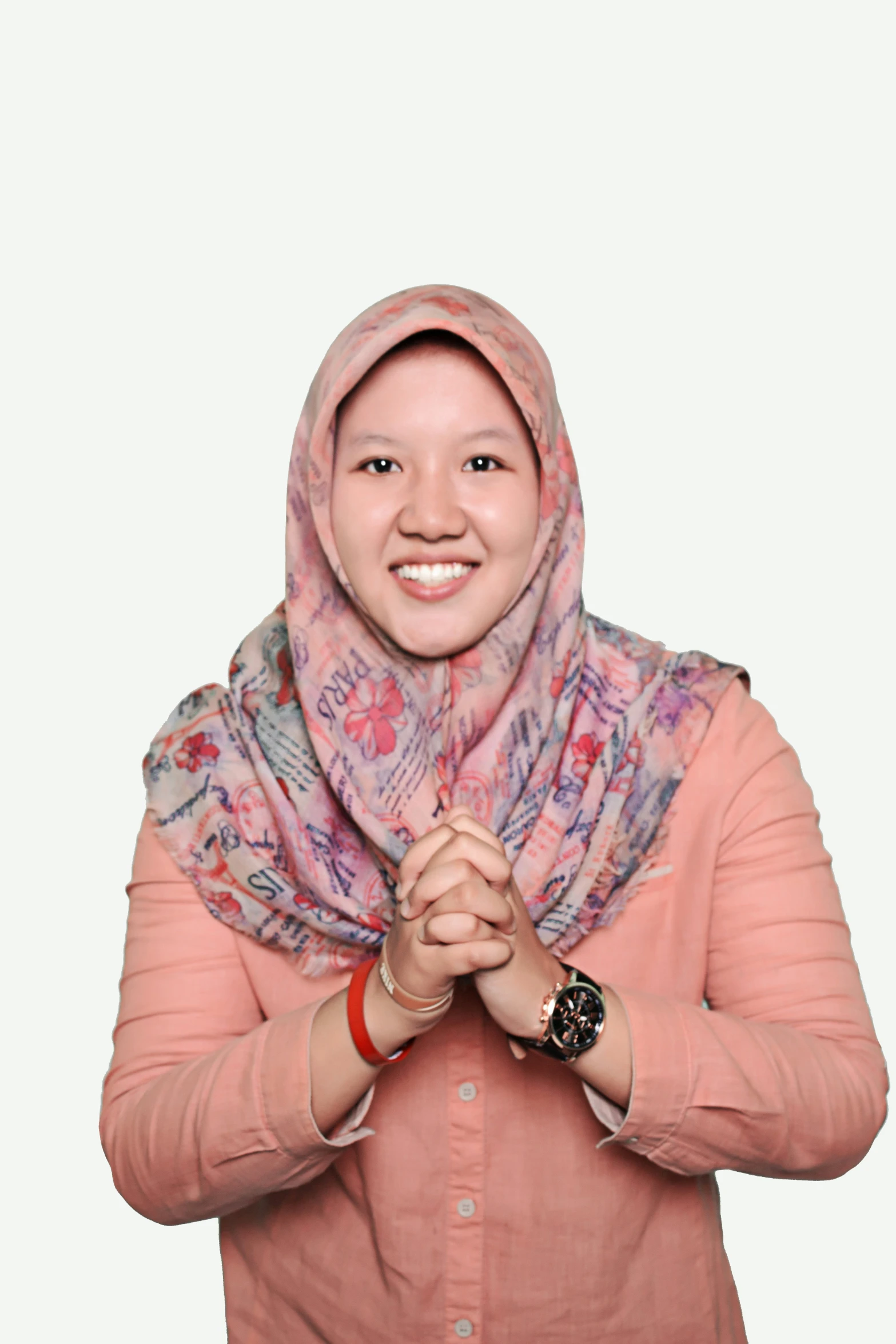 an oriental woman with a pink shirt and colorful scarf is posing with her hands in her pockets