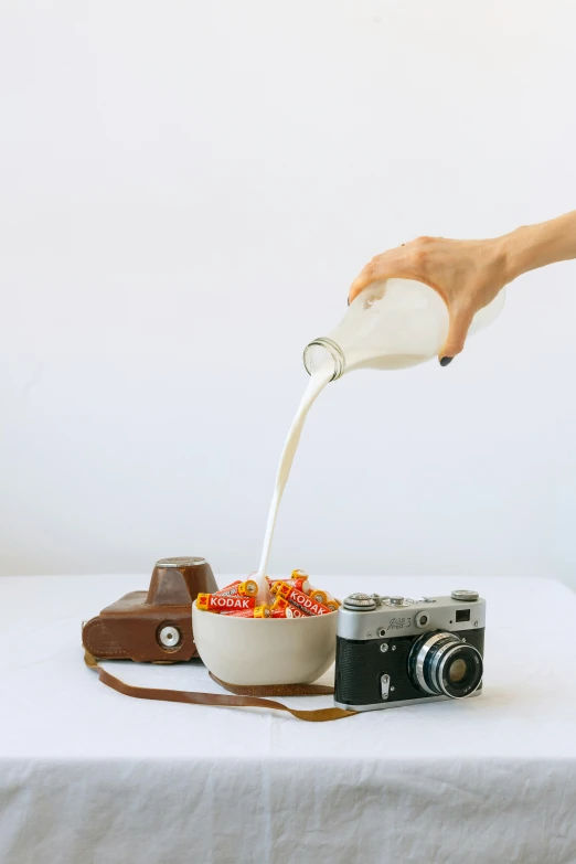 a person pouring soing into a bowl with candy corn