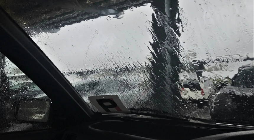 a wet windshield on a rainy day looking out of a window