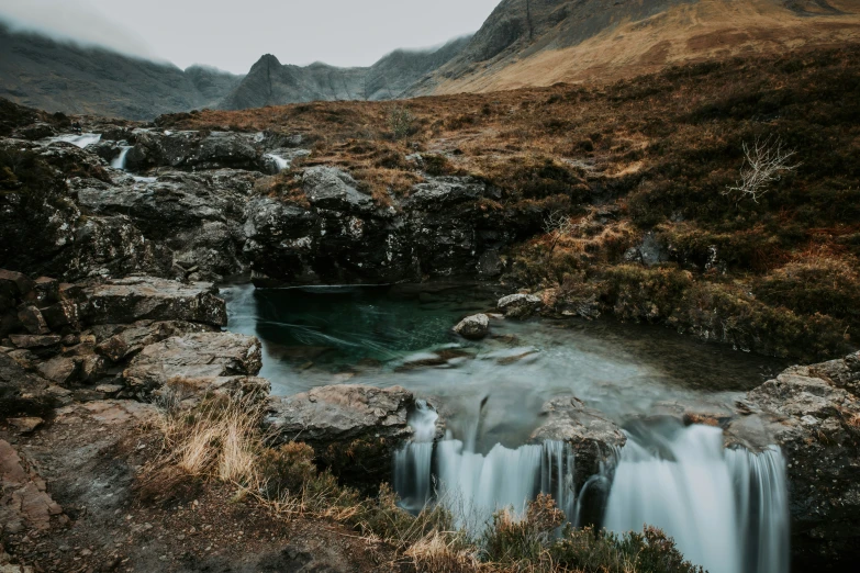 two waterfalls near a mountain on a sunny day