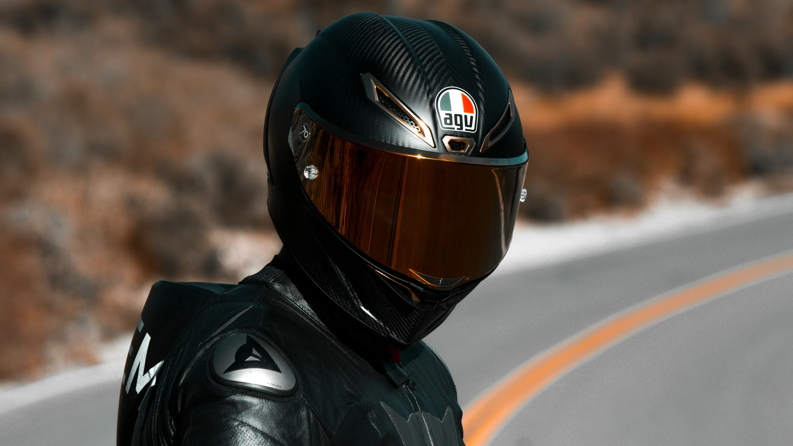 a person in a full leather outfit and helmet, riding on the highway