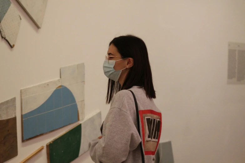 a woman is looking at some artwork on a wall