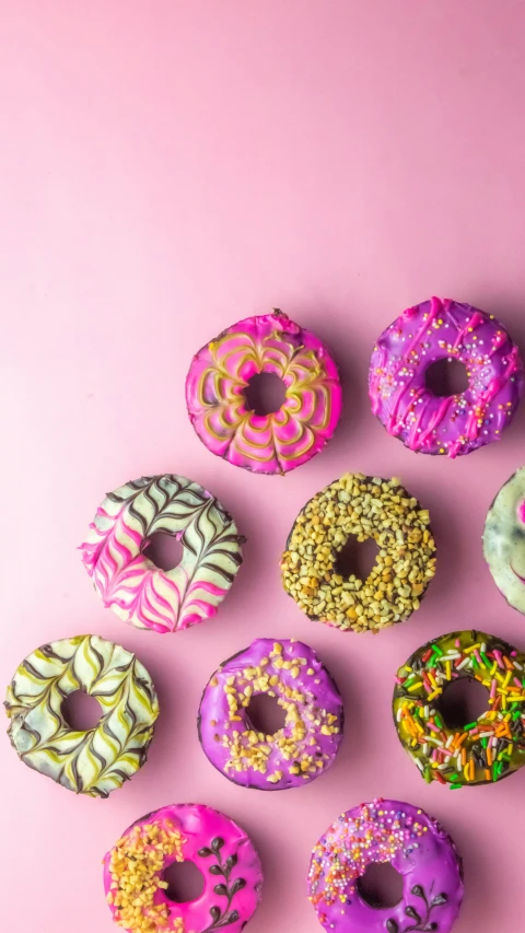 a bunch of donuts sit in a circle with sprinkles