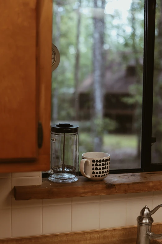 a small container next to a mug on a kitchen counter