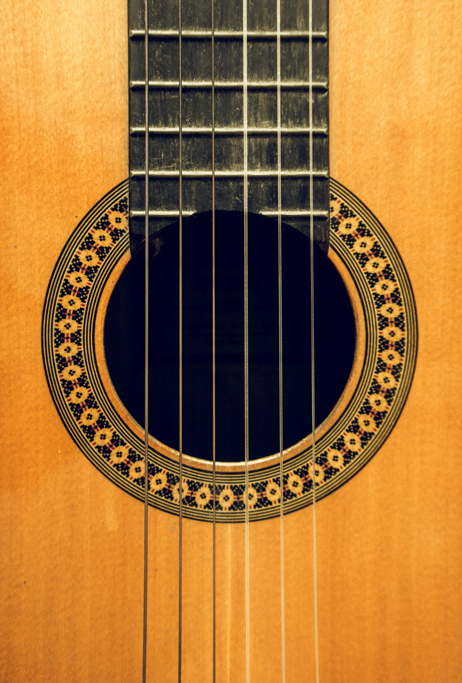 an acoustic guitar has a picture of a decorative pattern on its back