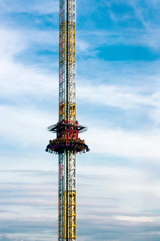 a tower with a large roller coaster in the middle of the day