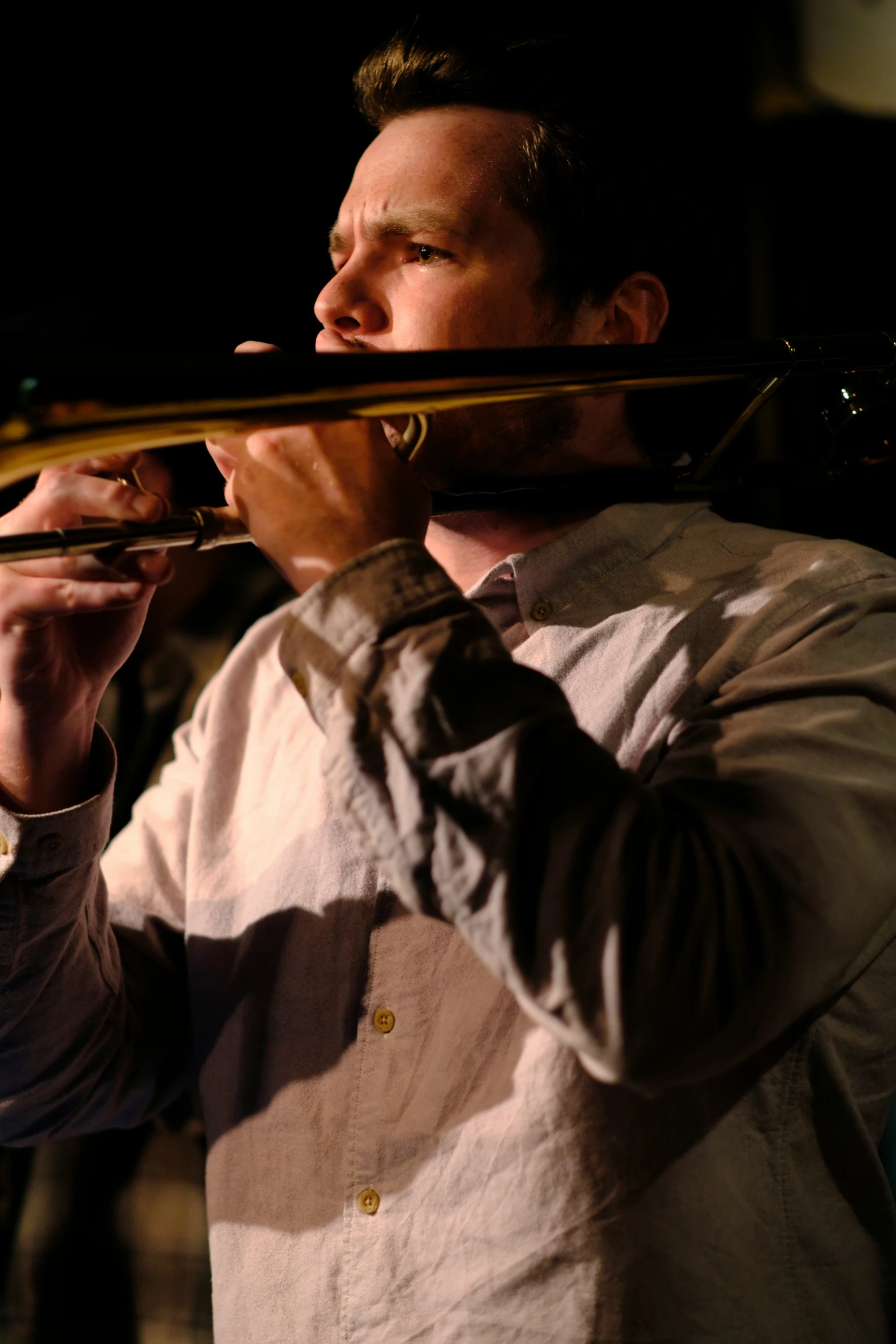 a man holding a trombone and playing one on it