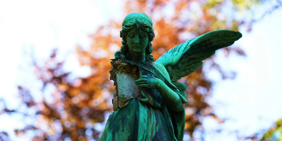 a statue in the background with a leaf in its arms