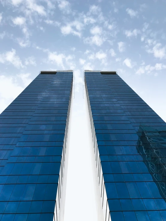 a picture of two tall buildings against a bright blue sky