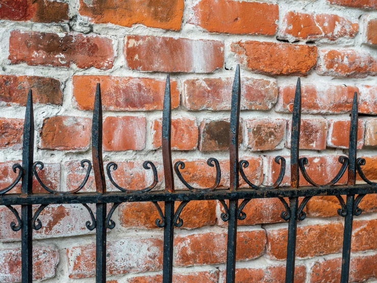 iron fence with red bricks as background