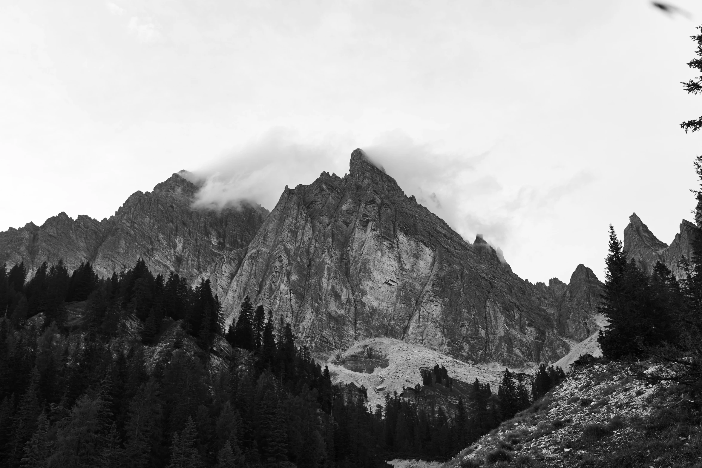 black and white picture of the mountains with clouds and mist