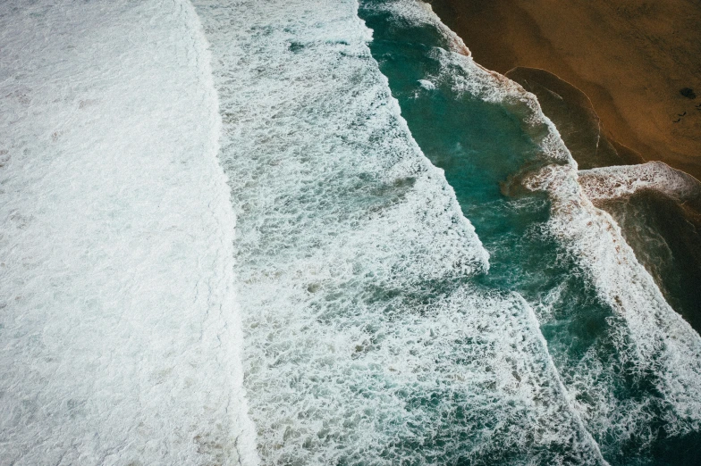 the aerial pograph shows waves crashing over the beach