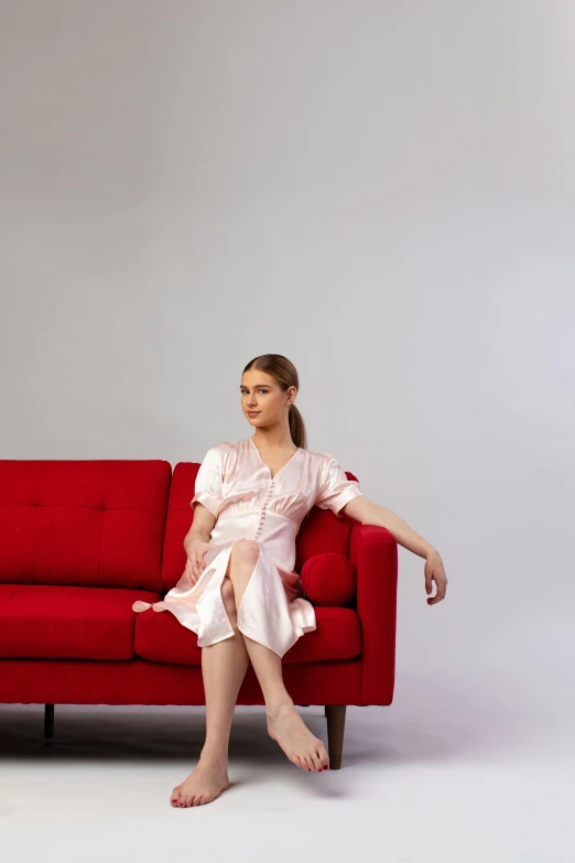 girl sitting on a red couch wearing pink