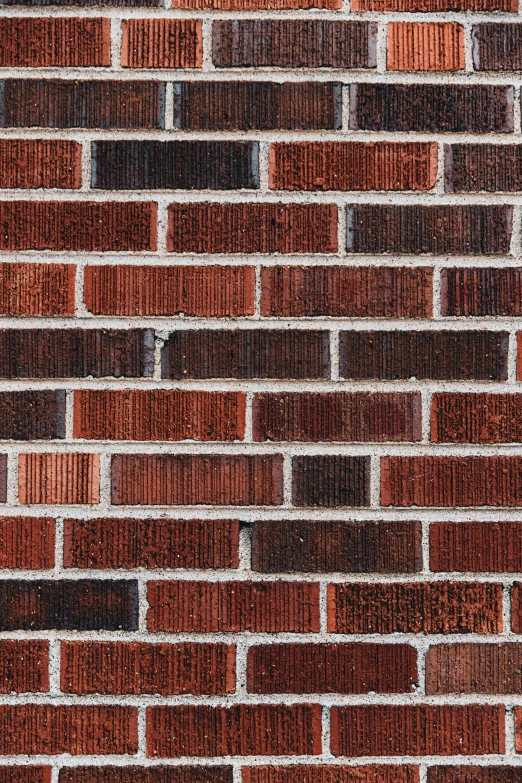 the old brick wall of a building is faded in red