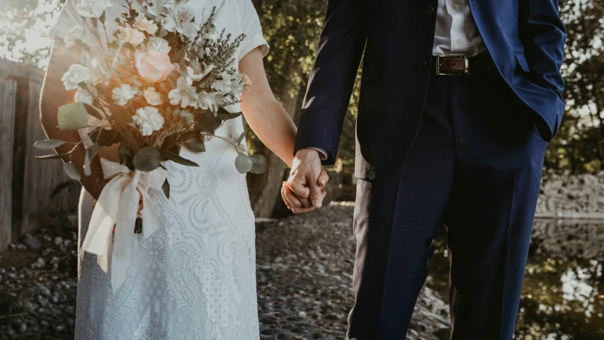 a couple holding hands during their wedding at a winery