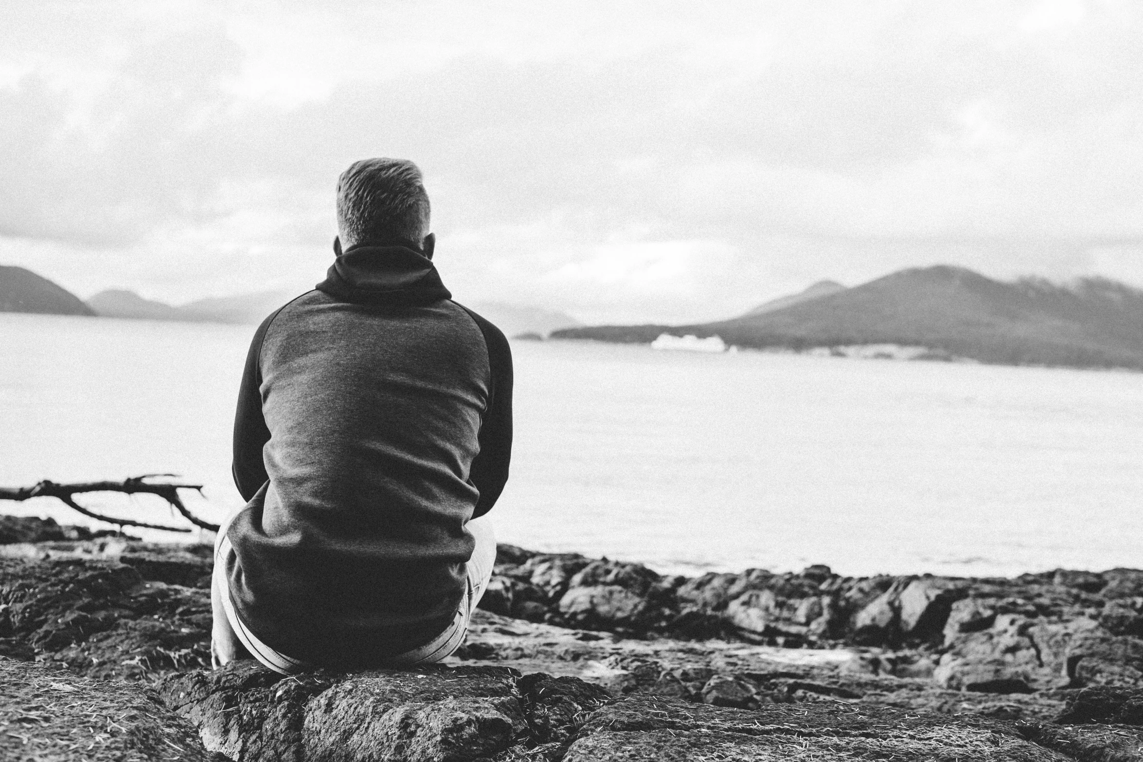 a man is staring out at the sea