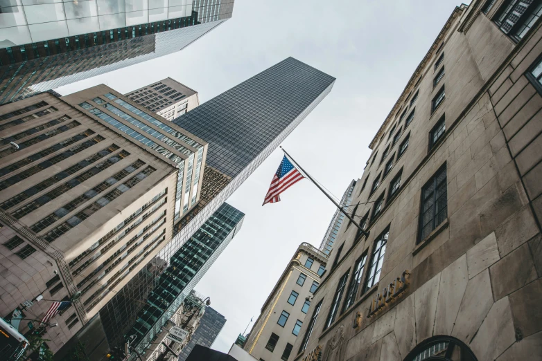 an american flag flying from a pole over a street