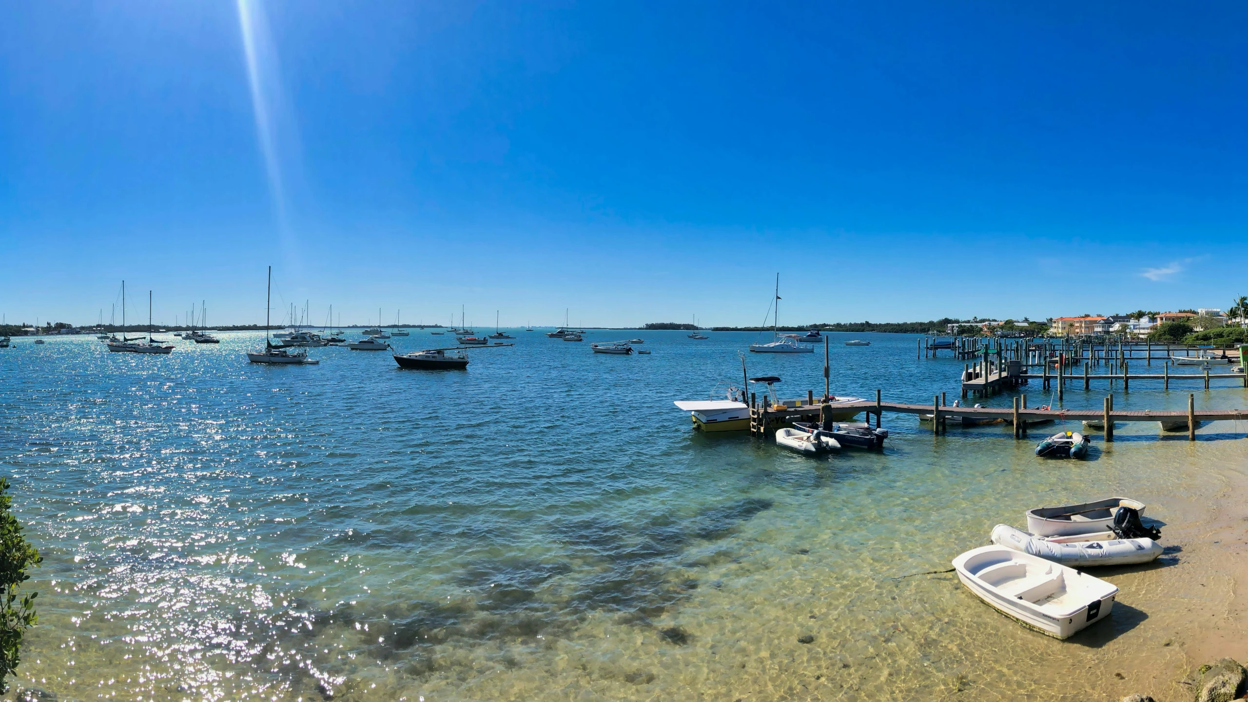 a sandy beach that has boats and houses near it