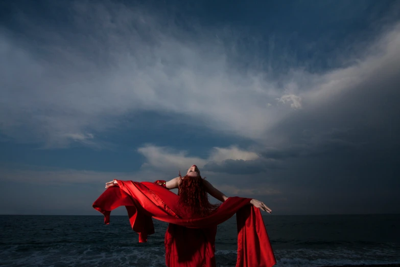 a woman in red clothing standing on the beach