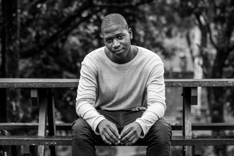 a man is sitting down on a wooden bench