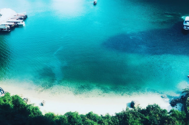 there are many boats in this turquoise lake