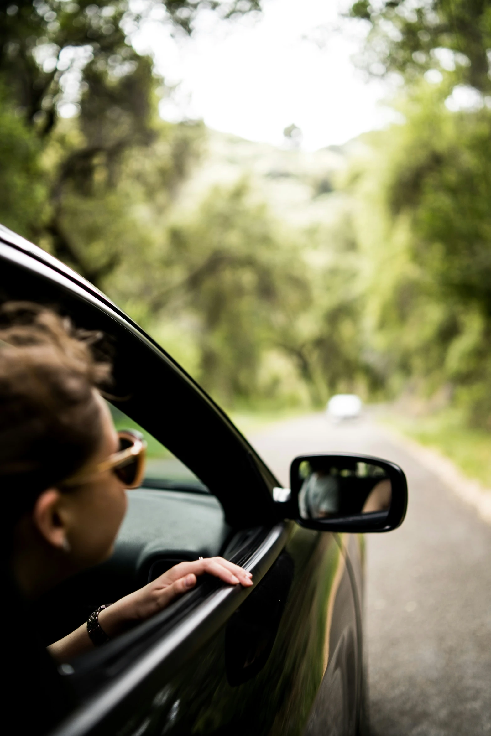 a woman in sunglasses leaning out of a car window