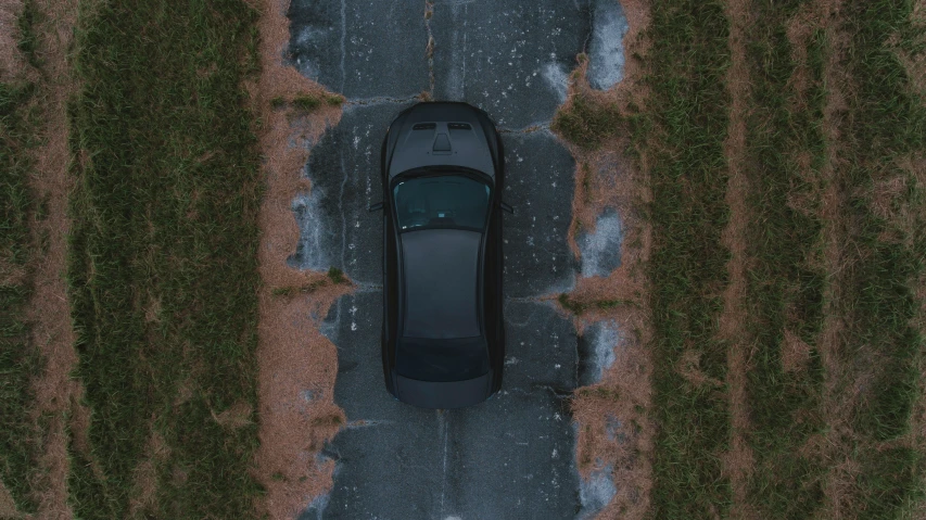 a car parked on the side of a road with grass