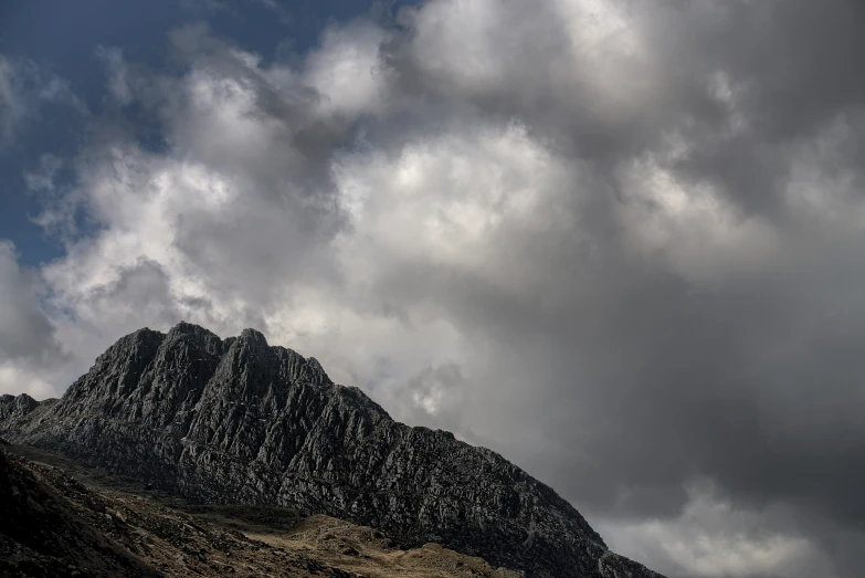 a tall mountain is covered in white clouds