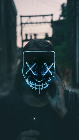 a person wearing an led mask that has crossed arrows on it