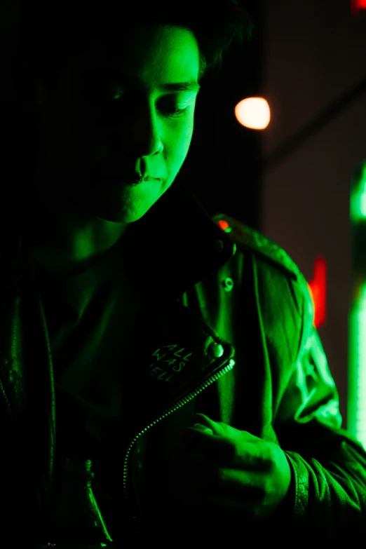 young man in a dark room looking at a cell phone