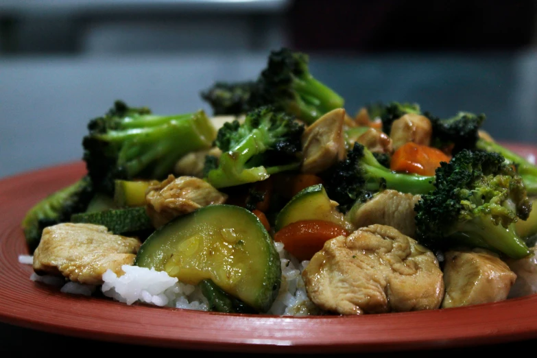 the plate has rice, cucumbers and broccoli on it