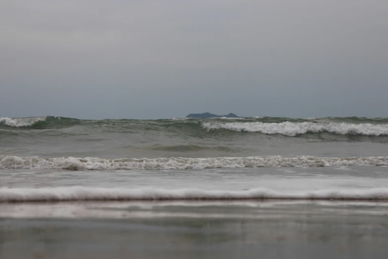 the view from an empty beach toward waves