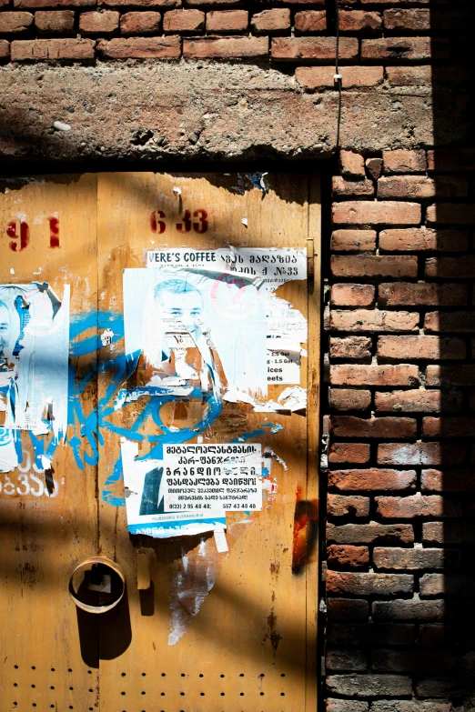 a rusty door with a bunch of stickers and papers