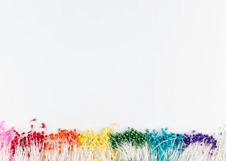 a rainbow of white straws with colored stems against a white background