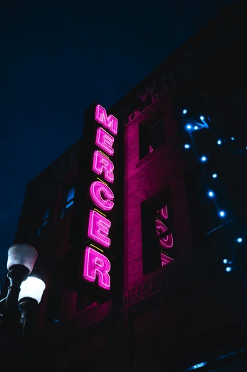 bright purple lights are shining on the front of a theatre