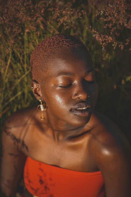 a woman wearing red poses in a field of green grass