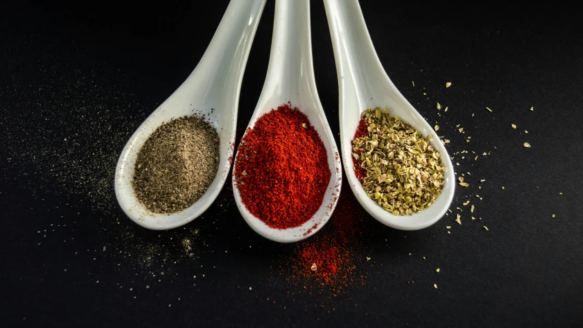 several different colors of seasoning sitting on a table