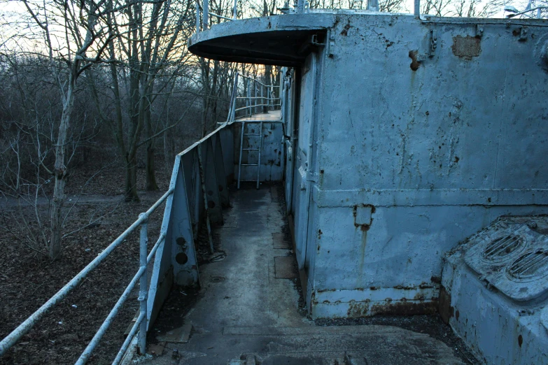 an old abandoned building with a ladder in the forest