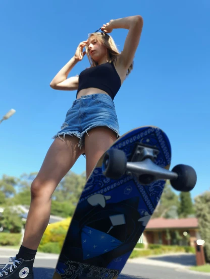 a woman in shorts standing next to a skateboard