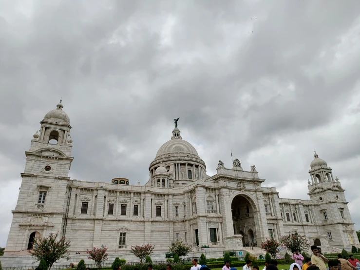 a bunch of people are gathered around a building with many spires