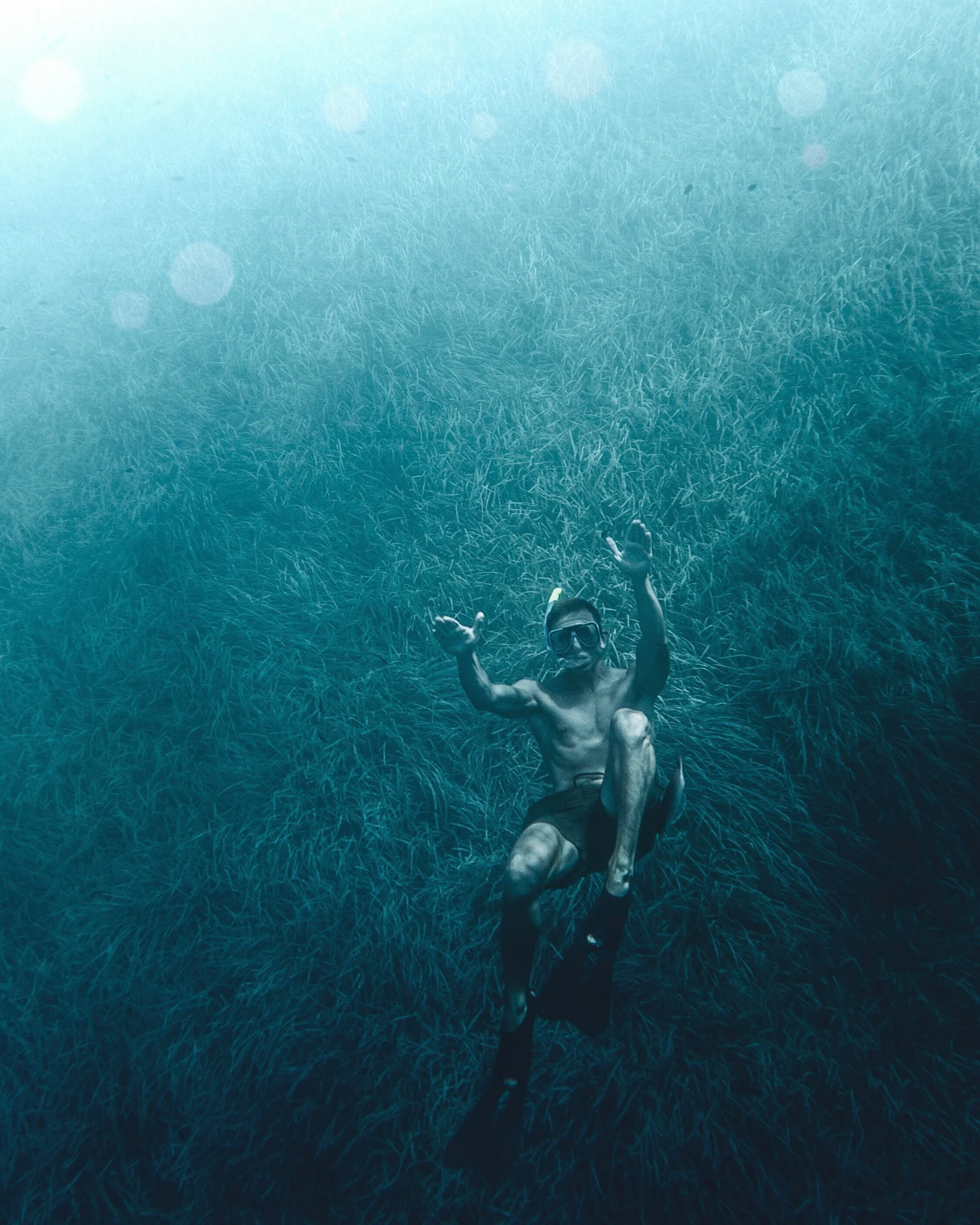 man is swimming under the water in an ocean